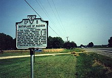 Madison's birthplace. It is on the west side of US 301 in front of Emmanuel Episcopal Church and is just north of the Rappahannock River bridge. Belle Grove plantation house, the actual birthplace, was located 400 yards east and is no longer in existence