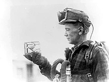 Mining foreman R. Thornburg shows a small cage with a canary used for testing carbon monoxide gas in 1928.