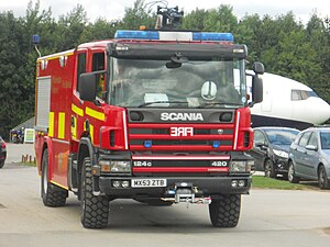 Red fire appliance with half-Battenburg side markings at Manchester Airport, England