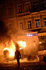 A person walks in front of a burning car during the Hrushevskoho Street riots in Kiev, Ukraine