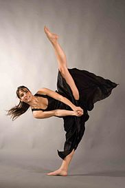 A ballet dancer performs a standing side split.