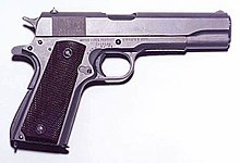 Photographie en couleurs, représentant une arme à feu (un Colt 45).