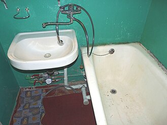 Ванная комната, оборудованная раковиной и ванной. Стены окрашены масляной краской