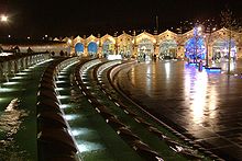 Ночной вид на привокзальную площадь, украшенную длинными изогнутыми фонтанами с декоративной подсветкой. В дальнем конце площади виден сводчатый фасад Шеффилдского железнодорожного вокзала.