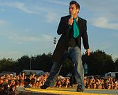 Colour photograph of Robbie Williams performing live on stage in 2006.