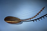 Ennanga, Uganda Type 1. Ladle shaped. The string support is below the leather sound table; it pokes through the table at the neck, wedging into the neck and keeping it from being pulled further by the strings.