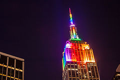 The Empire State Building illuminated by rainbow-colored lighting at night