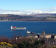 At Gourock a ship heads for the container cranes at Greenock, passing the Caledonian MacBrayne Dunoon ferry. Across the firth MV Kenilworth leaves Kilcreggan for Helensburgh.