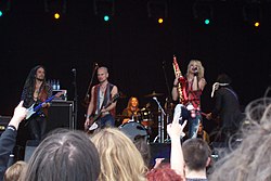 Hanoi Rocks esiintymässä syyskuussa 2005. Etualalla vasemmalta oikealle Conny Bloom, Andy Christell ja Michael Monroe. Taustalla rummuissa Lacu ja äärimmäisenä oikealla Andy McCoy selin.