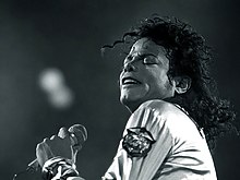 Black and white photo of Jackson holding a microphone and singing.
