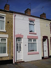 A colour photo of a white and pink cladded house
