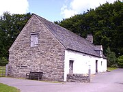 A 1735 Welsh longhouse in the 'Dartmoor' style; the gable end drain can just be made out below the modern bench