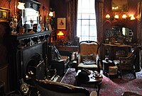 Victorian style "sitting room" with a fireplace in the Sherlock Holmes Museum, London