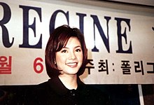 A photo of a woman with a banner behind her bearing the name Regine and Korean text