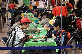 Children (hands holding cards) competing at a Pokémon TCG junior tournament