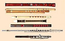 Picture of a collection of flutes. Contains Shinobue and other flutes spread out on a violet velveteen cloth.