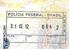 Photographie en couleurs, représentant un tampon des services de l'immigration brésilienne, sur un passeport.