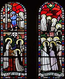 一列に並ぶ修道女の姿を描いた教会のステンドグラス