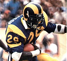 Eric Dickerson running with the ball in a football game.