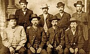 Bat Masterson (segundo a direita de pé), Wyatt Earp (segundo a esquerda sentado) e outros delegados durante a era do Velho Oeste