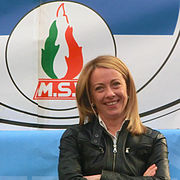 Giorgia Meloni in 2014 with the tricolour flame in the background
