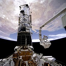An astronaut conducting an EVA while the Hubble Space Telescope is in the payload bay