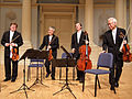 Image 11A modern string quartet. In the 2000s, string quartets from the Classical era are the core of the chamber music literature. From left to right: violin 1, violin 2, cello, viola (from Classical period (music))