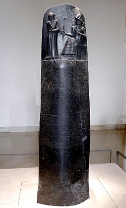 Hammurapi törvényoszlopa. Fent: a király hallgatja (Samas) nap- és igazságisten parancsolatait