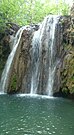 Das Wasser des Blederija-Falls fällt acht Meter wie ein Vorhang in ein wannenartiges türkisfarbiges Becken.