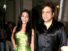 Govinda in a black satin shirt with Amrita Rao, a young actress