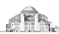 A reddish building topped by a large dome and surrounded by smaller domes and four towers
