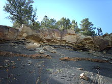 rock striations with dark light boundary and surveying rod