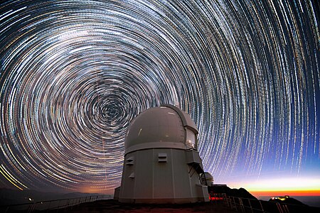 This image shows stars appearing to “trail” around the south celestial pole (at the center of the circles) above the Southern Astrophysical Research Telescope