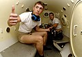 Two United States Navy sailors inside a decompression chamber about to undergo training