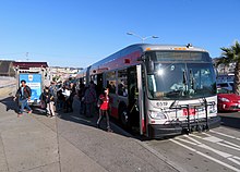 Passengers boarding an articulated bus