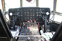 This is the cockpit of a Boeing 377. It does not include the stations of the navigator and flight engineer. You have yokes, rudder pedals, thrust levers, and a lot of "steam gauges", as is typical for this era of aircraft.