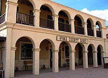 Photographie des studios Old Tucson, on y voit un bâtiment avec un vaste balcon au premier et dernier étage, et le rez-de-chaussée est marqué par un couloir