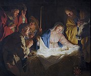 مغارة الميلاد، ويظهر فيها يوسف ومريم مع يسوع طفلاً، وفي الخلفية أضواء شجرة عيد الميلاد