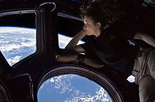 Woman seeing the Earth from space through a window