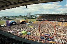 Un stade sportif reconverti en terrain de concert et rempli de milliers de personnes.