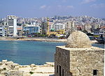 إطلالة على مدينة صيدا الحديثة، ويظهر جانبٌ من القلعة البحرية في مقدمة الصورة.