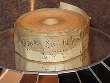 An aged roll of paper tape perhaps 1–2 inches (2.5–5.1 cm) wide; on the outside is written "BASIC 8K without cassette" and "July 2" in blue biro pen.