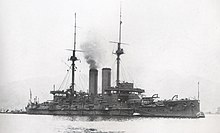 Великий військовий корабель із димом, що піднімається з димової труби