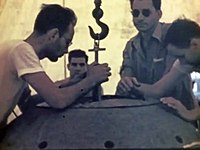 The two physicists Louis Slotin (with sunglasses) and Harry Daghlian Jr. (seated middle) during the Trinity Test preparation in July 1945. Both physicists died following supercriticality accidents.
