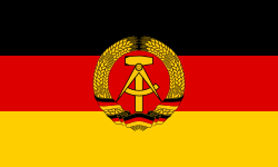 The flag of East Germany (1959–90). It differs from the West German flag by the presence of a communist symbol in the center, and it fell out of use when Germany was reunified after the fall of the Berlin Wall.