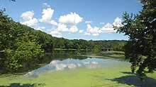 A picture of the Croton River on a sunny summer day with a few clouds in the sky.