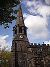 The west end of a Gothic church showing its stepple with a square lower stage, octagonal belfry stage surmounted by a spire