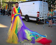a man in a rainbow-colored tulle gown with a long train