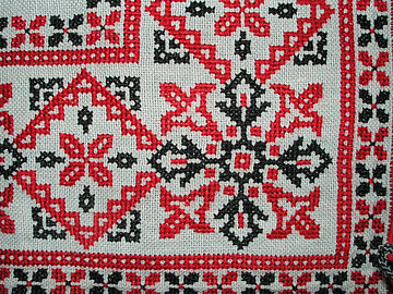 Félfiguratív ornamentika - a növényvilág elemeit egyszerűsítetten ábrázoló minták - magyar keresztszemes hímzésű textiltárgyon