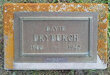 Bronze plaque mounted on a granite base, inscribed with his name, birth year and death year, and a smaller bronze plate attached beneath with his wife's name and dates